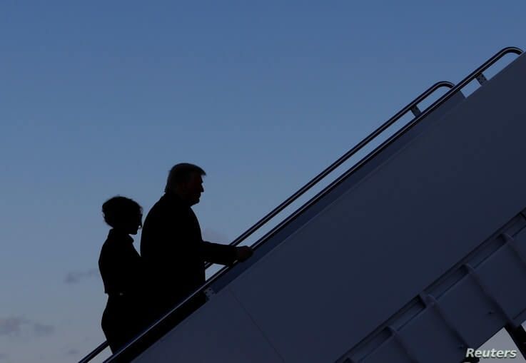 U.S. President Donald Trump departs next to first lady Melania Trump from the Joint Base Andrews, Maryland.