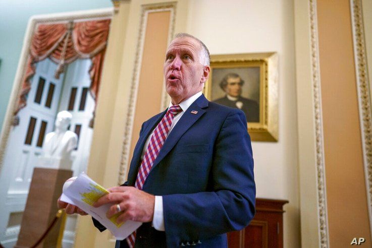 Sen. Thom Tillis, R-N.C., talks to a reporter as lawmakers work to advance the $1 trillion bipartisan bill, at the Capitol in…