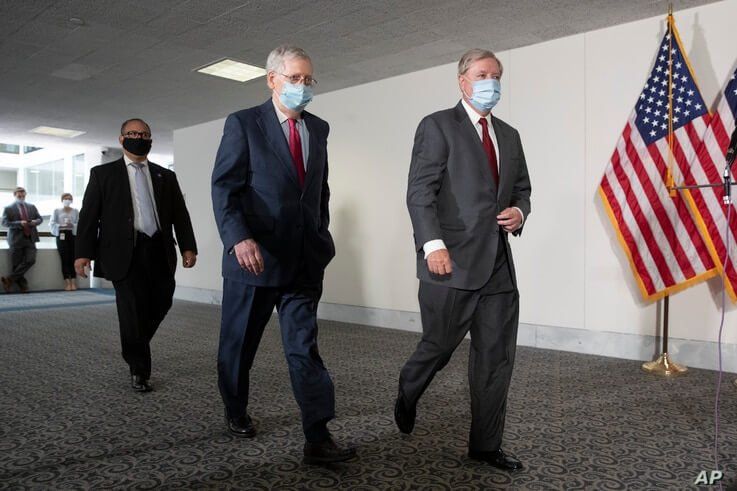 FILE - Senate Republican Majority Leader Mitch McConnell, left, and Republican Sen. Lindsey Graham, both wearing face masks to protect against the coronavirus walk on Capitol Hill, in Washington, May 19, 2020. 