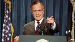 FILE - President George H.W. Bush acknowledges a reporter during a news conference at the White House, Dec. 5, 1991.
