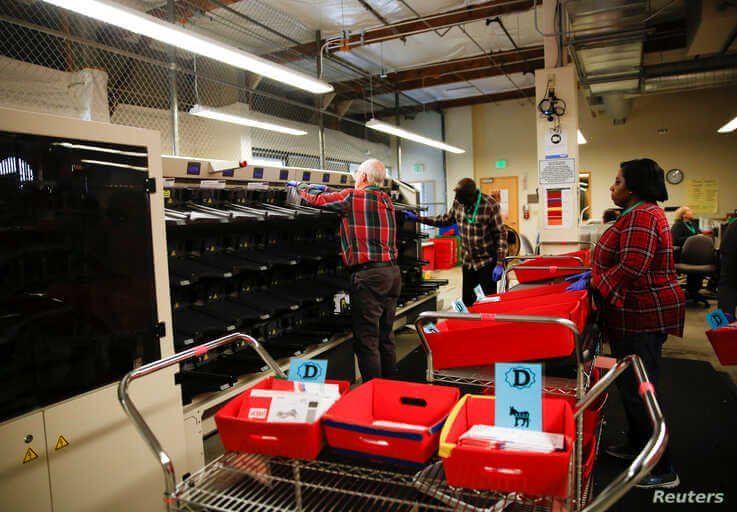 Workers transport sorted Democratic Party ballots into bins to be opened and scanned during the presidential primary at King…