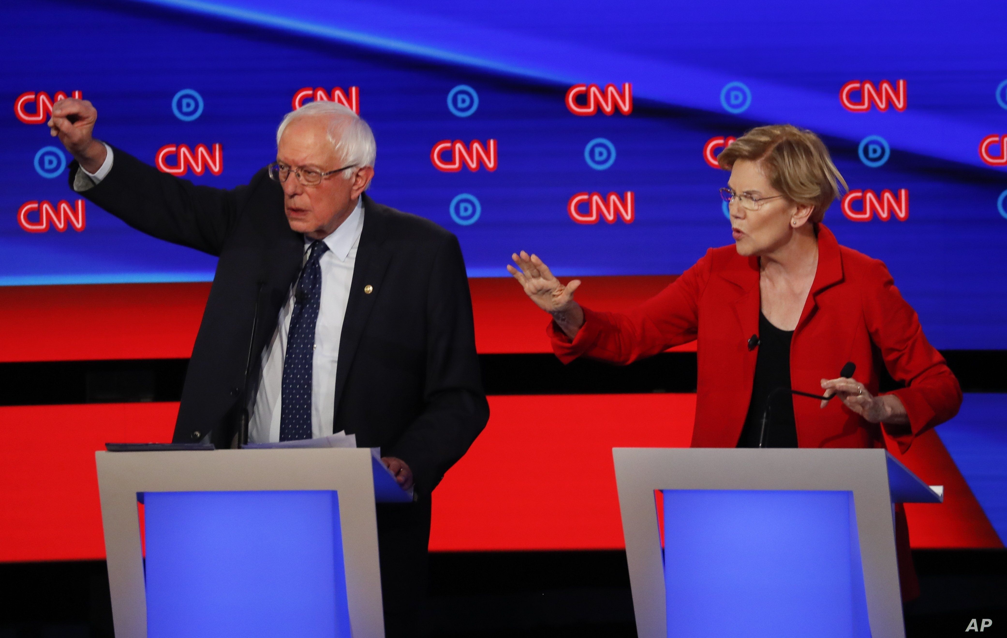 Sen. Bernie Sanders, I-Vt., and Sen. Elizabeth Warren, D-Mass., talk during in the first of two Democratic presidential primary debates hosted by CNN in the Fox Theatre in Detroit, July 30, 2019. 