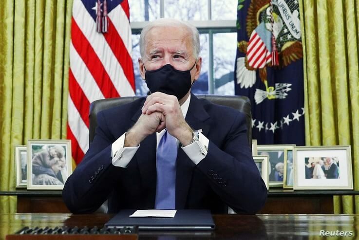 FILE PHOTO: U.S. President Joe Biden signs executive orders in the Oval Office of the White House in Washington, after his…