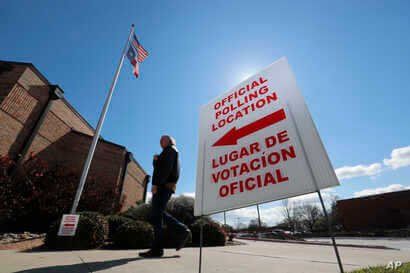 Using both the English and Spanish language, a sign points potential voters to an official polling location during early voting…