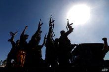 Newly recruited Houthi fighters chant slogans as they ride a military vehicle during a gathering in the capital Sanaa to…