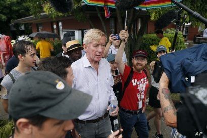 FILE - Republican presidential candidate and former Massachusetts Gov. Bill Weld, center, walks to the grand concourse during a visit to the Iowa State Fair, in Des Moines, Iowa, Aug. 11, 2019.