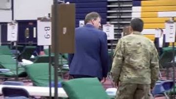 The Governor of New Hampshire visits a gymnasium retrofitted as an overflow hospital.