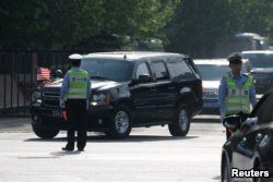 FILE - A motorcade leaves the U.S. Embassy after U.S. officials had trade talks with Chinese counterparts, in Beijing, China, May 4, 2018.