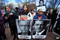 FILE - Amanda Bayer, left holding banner, and Marisol Maqueda, right with banner, from Mexico whose daughter Maria Torres also from Mexico City is a DACA recipient finishing her masters degree in Arizona, join a rally outside the White House in Washington