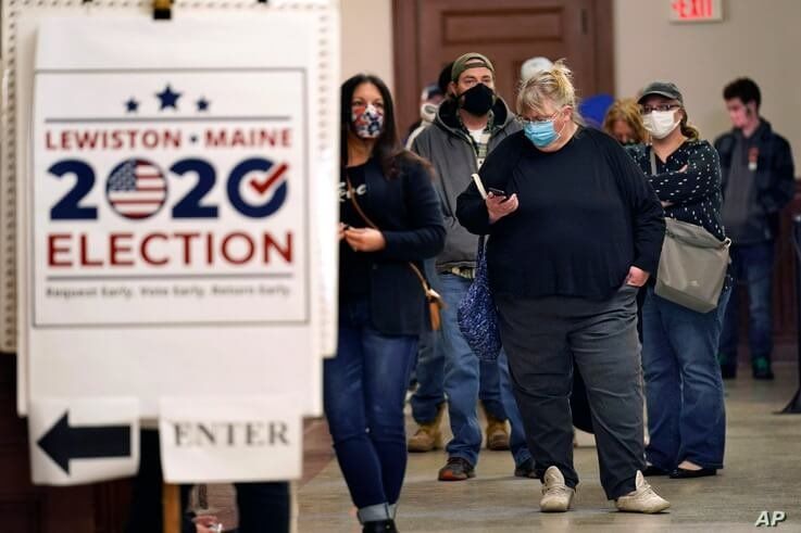 Residents wait to cast their absentee ballots during early voting, Friday, Oct. 30, 2020, in Lewiston, Maine. (AP Photo/Robert…