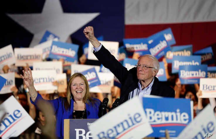 Democratic presidential candidate Sen. Bernie Sanders, I-Vt., right, with his wife Jane, raises his hand as he speaks during a…