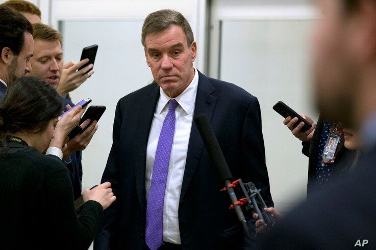 Sen. Mark Warner, D-Va., talks to reporters as he walks to attend the impeachment trial of President Donald Trump on charges of…