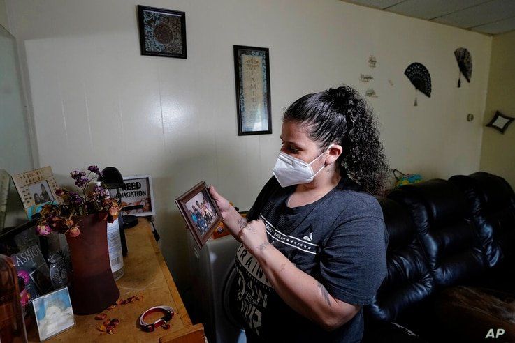 Roxanne Schaefer holds a photograph in the living room of her apartment, in West Warwick, R.I., Tuesday, July 27, 2021…