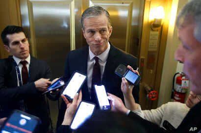 Sen. John Thune, R-S.D., answers reporters questions outside his office prior to the start of the impeachment trial of…