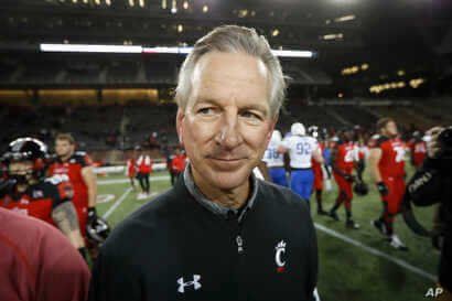 FILE - In this Nov. 18, 2016 file photo, Cincinnati coach Tommy Tuberville walks off the field after the team's NCAA college…