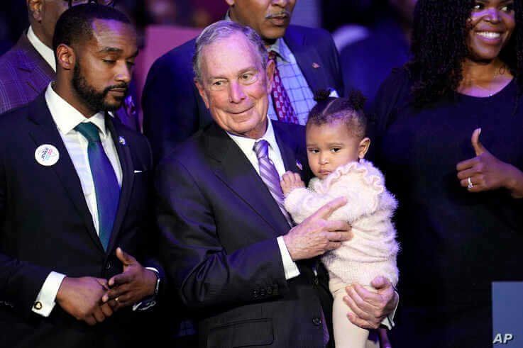 Democratic presidential candidate and former New York City Mayor Michael Bloomberg is joined on stage by supporters during his…