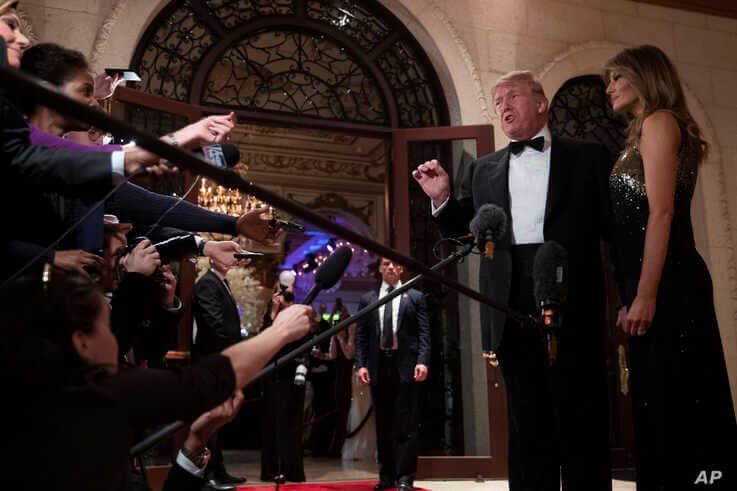 First lady Melania Trump listens as President Donald Trump speaks to reporters before his New Year's Eve party at his Mar-a…