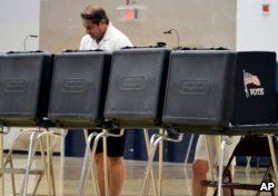 A voter looks over a ballot during New Mexico's primary elections at La Cueva High School in Albuquerque, N.M., June 5, 2018.