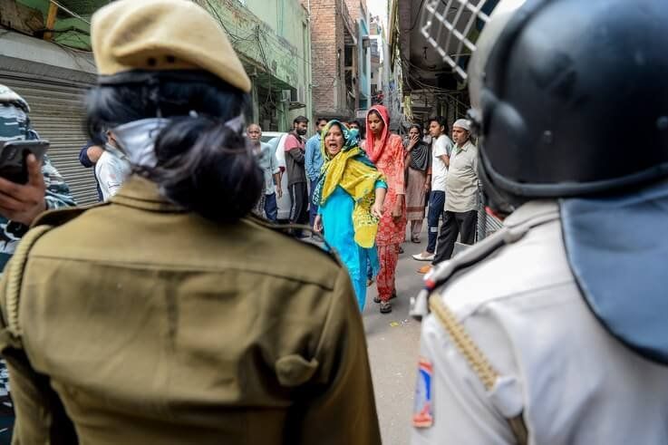 A Muslim woman (C) shouts at security personnel that patrol on the streets in Shaheen Bagh area after removing demonstrators…