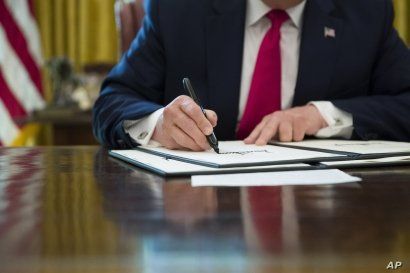 President Donald Trump signs an executive order to increase sanctions on Iran, at the White House, June 24, 2019.