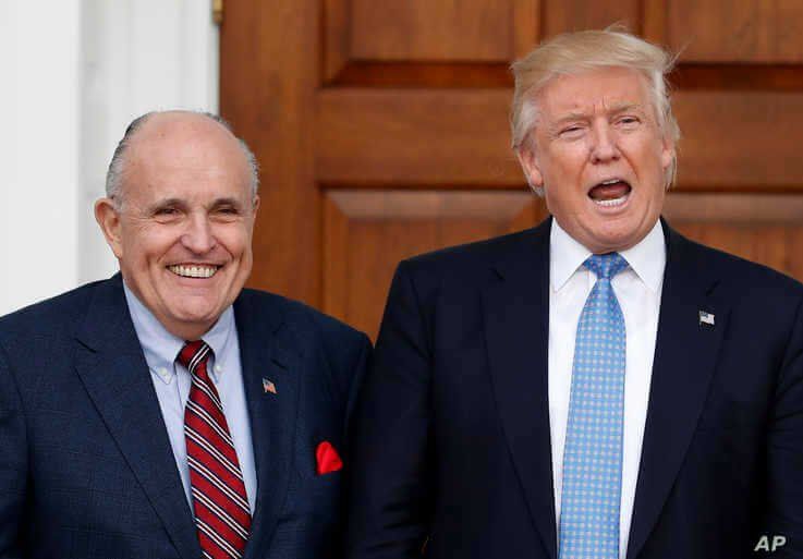 President-elect Donald Trump calls out to media as he and former New York Mayor Rudy Giuliani pose for photographs as Giuliani arrives at the Trump National Golf Club Bedminster clubhouse, Nov. 20, 2016, in Bedminster, N.J.