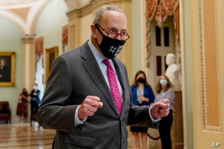 Senate Majority Leader Chuck Schumer of N.Y. walks off the Senate floor and pumps his fists as the Senate approves a $1…