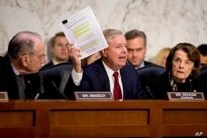 Chairman Lindsey Graham, R-S.C., center, accompanied by Sen. Chuck Grassley, R-Iowa, left, and Ranking Member Sen. Dianne…