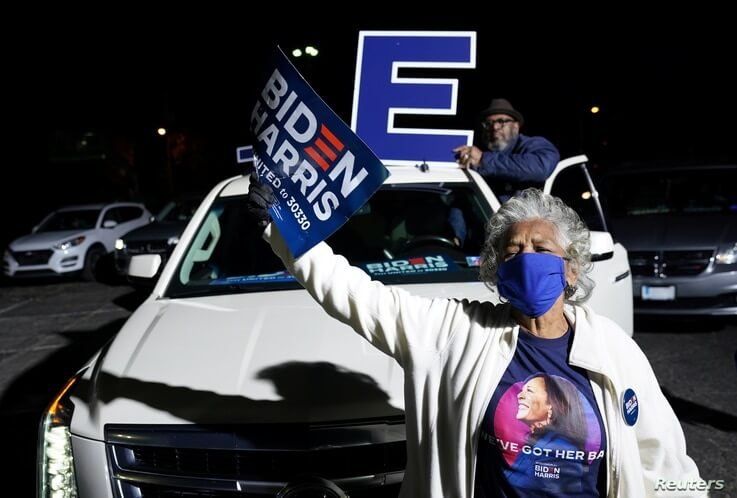 Supporters wave signs as Democratic U.S. presidential nominee and former Vice President Joe Biden holds a drive-in campaign…