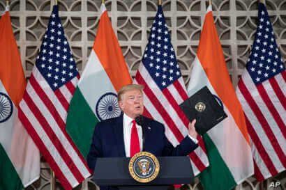 U.S.President Donald Trump holds up his prepared speech that he didn't use as he speaks with business leaders at a roundtable…