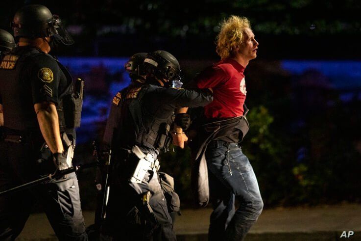 Portland police make arrests on the scene of the nightly protests at a Portland police precinct on Sunday, Aug. 30, 2020 in…