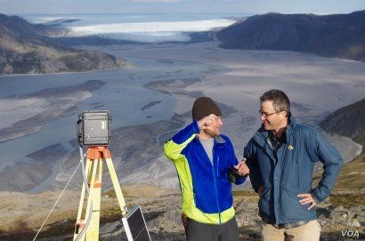 UCLA geography graduate student Lincoln Pitcher (left) and UCLA geography professor Laurence C. Smith overlook the mighty Isortoq River, where meltwater leaves the Greenland ice sheet to flow to the ocean seen in the distance. (UCLA/Lawrence C. Smith