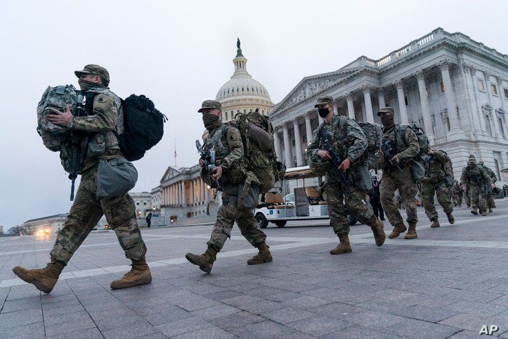 National Guard soldiers walk out of the U.S. Capitol, Saturday, Jan. 16, 2021, in Washington, as security is increased ahead of…