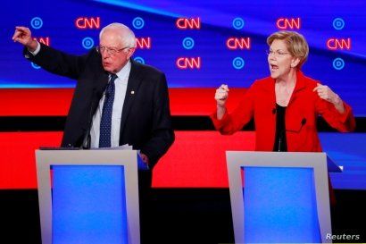U.S. Senators Bernie Sanders (l) and Elizabeth Warren speak on the first night of the second 2020 Democratic presidential debate in Detroit, Michigan, July 30, 2019.
