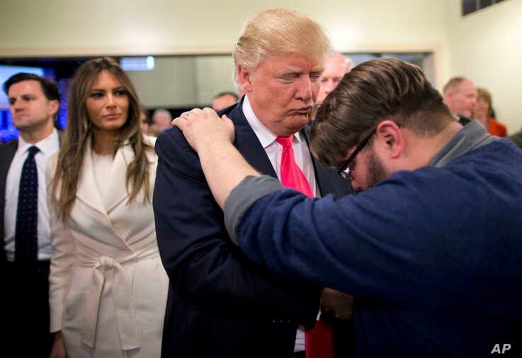 FILE - In this Jan. 31, 2016, file photo, Pastor Joshua Nink, right, prays for then Republican presidential candidate Donald…