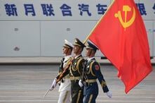 Soldiers of People's Liberation Army (PLA) march in formation with a Chinese Communist Party flag during a rehearsal before…