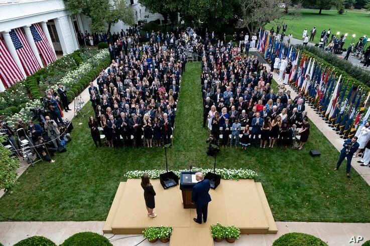 President Donald Trump, center, stands with Judge Amy Coney Barrett as they arrive for a news conference to announce Barrett as his nominee to the Supreme Court, in the Rose Garden at the White House in Washington, Sept. 26, 2020.