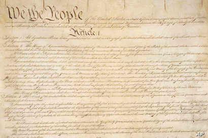 This photo made available by the U.S. National Archives shows a portion of the first page of the United States Constitution.