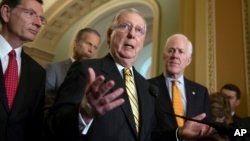 Senate Majority Leader Mitch McConnell, R-Ky., center, joined from left by Sen. John Barrasso, R-Wyo., Sen. John Thune, R-S.D., and Majority Whip John Cornyn, R-Texas, tells reporters he intends to cancel the traditional August recess, June 5, 2018.