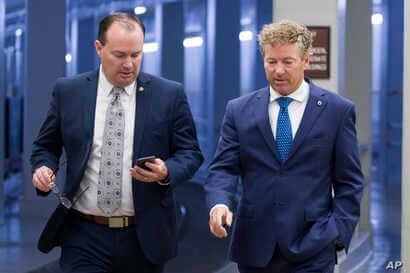 FILE - Senators Mike Lee and Rand Paul, both Republicans, walk to a vote on Capitol Hill, in Washington, June 27, 2019.