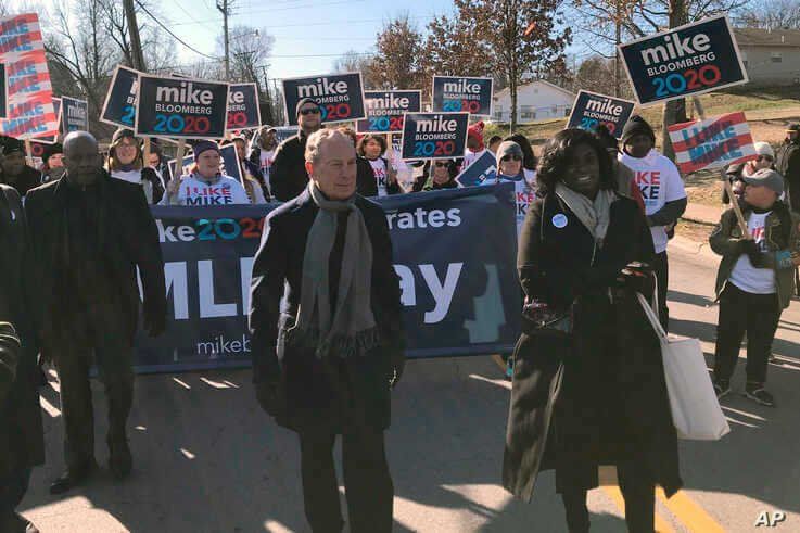 Former New York City Mayor, and Democratic presidential candidate Michael Bloomberg walks with supporters along the route of the Little Rock 