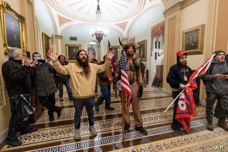 FILE - Supporters of President Donald Trump are confronted by U.S. Capitol Police officers outside the Senate Chamber inside the Capitol in Washington, Jan. 6, 2021.
