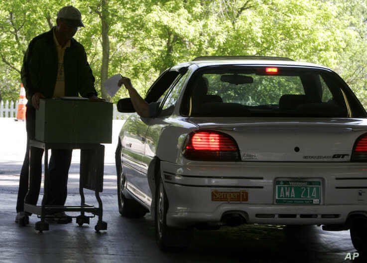 FILE - A voter casts a ballot from an auto in a special election on June 6, 2006 in Williston, Vt.