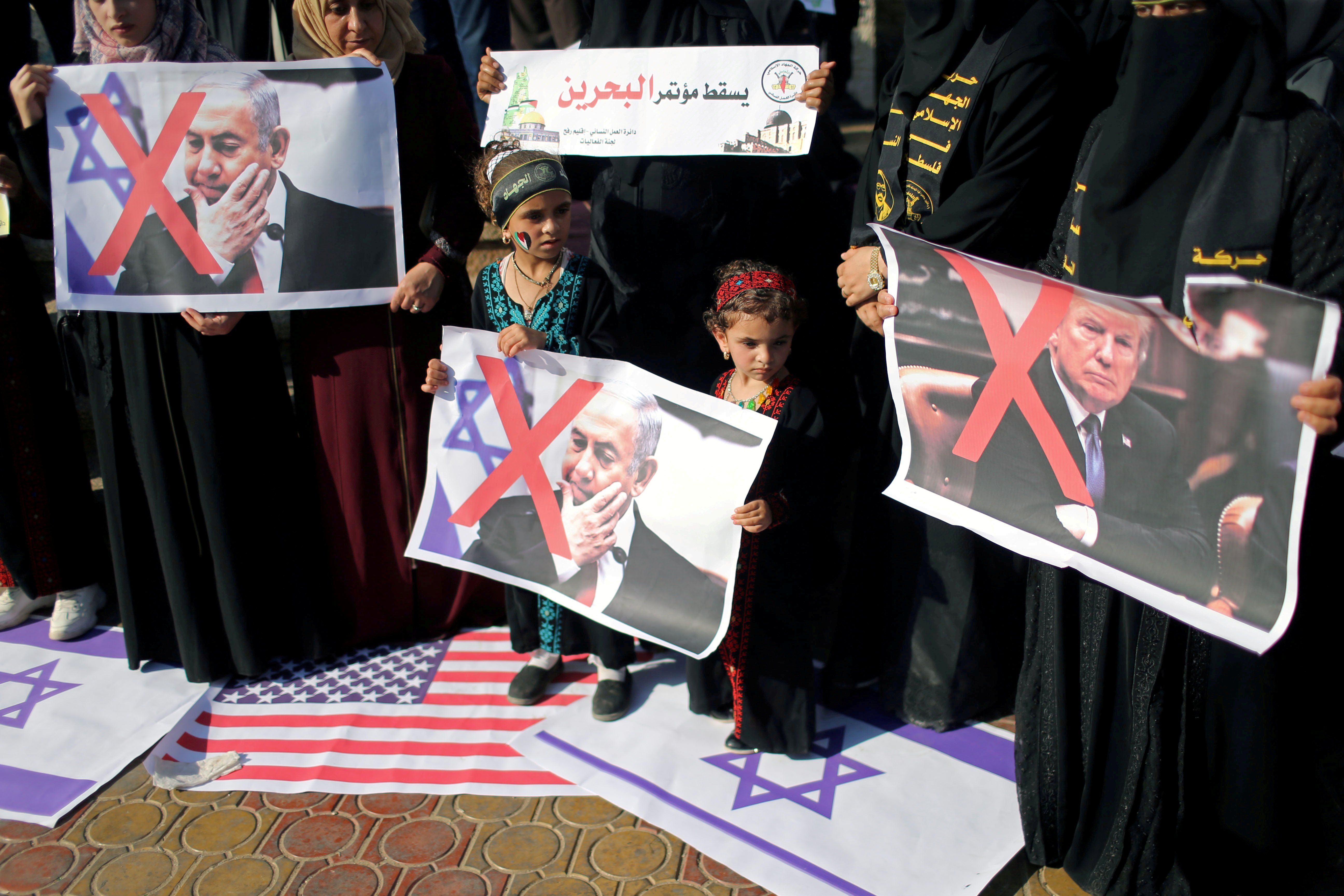 FILE - Palestinians step on Israeli and U.S. flags and hold posters of U.S. President Donald Trump and Israeli Prime Minister Benjamin Netanyahu during a protest against Bahrain's workshop for U.S. peace plan, in the Gaza Strip June 18, 2019