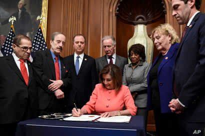 House Speaker Nancy Pelosi of Calif., signs the resolution to transmit the two articles of impeachment against President Donald…