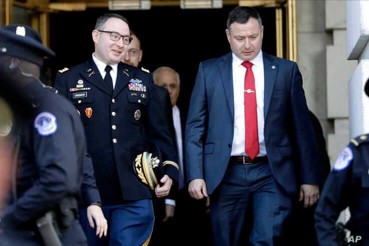 FILE - Lt. Col. Alexander Vindman, left, walks with his twin brother, Yevgeny Vindman, after testifying before the House Intelligence Committee, on Capitol Hill in Washington, Nov. 19, 2019.