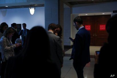 Reporters wait outside of closed U.S. House Intelligence Committee rooms while Intelligence Community Inspector General Michael Atkinson testifies on a whistleblower complaint, on Capitol Hill, in Washington, Sept. 19, 2019.