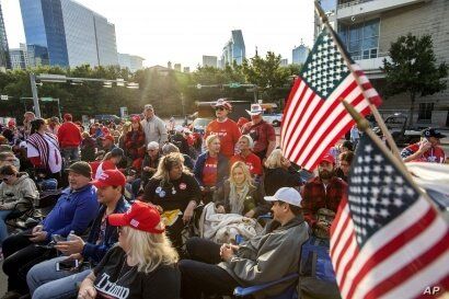 Supporters of President Donald Trump wait to enter a campaign rally as the sun rises, Oct. 17, 2019, outside the…