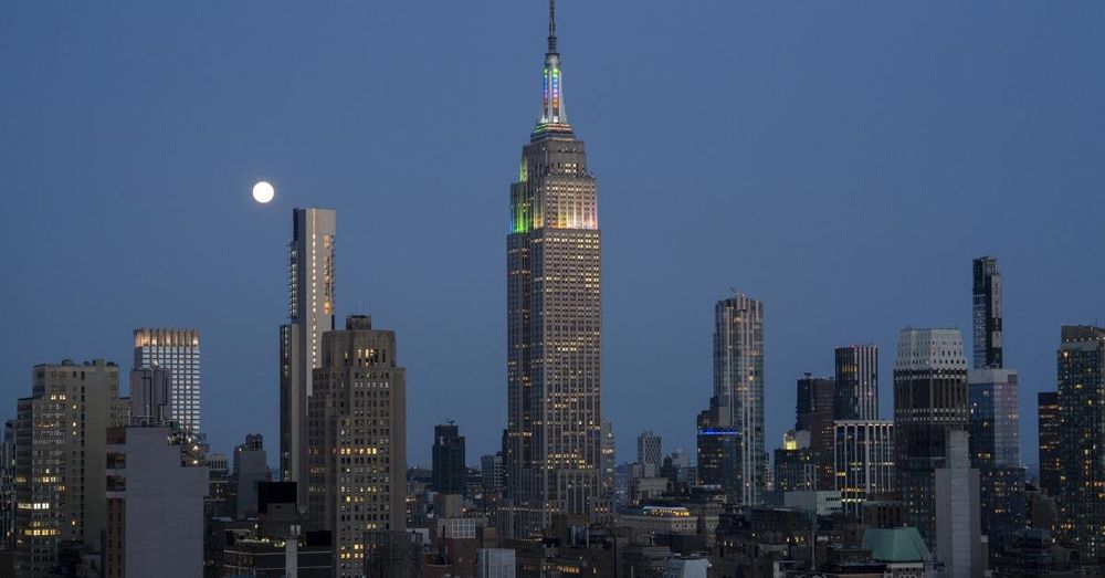 Two people climb to the top of Empire State Building and raise banner: 'power of love'