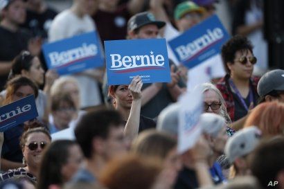 FILE - Supporters wave signs in support of Democratic presidential candidate Senator Bernie Sanders, as he speaks during a campaign rally in Denver, Colorado, Sept. 9, 2019. 