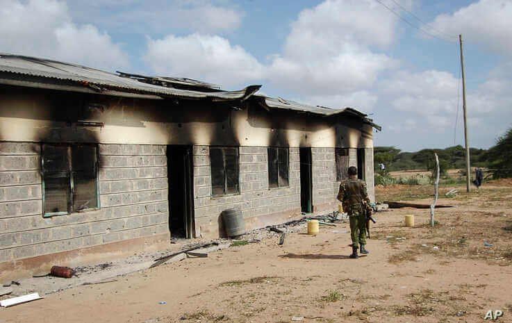 A member of Kenya's security forces walks past a damaged police post after an attack by al-Shabab extremists in the settlement…